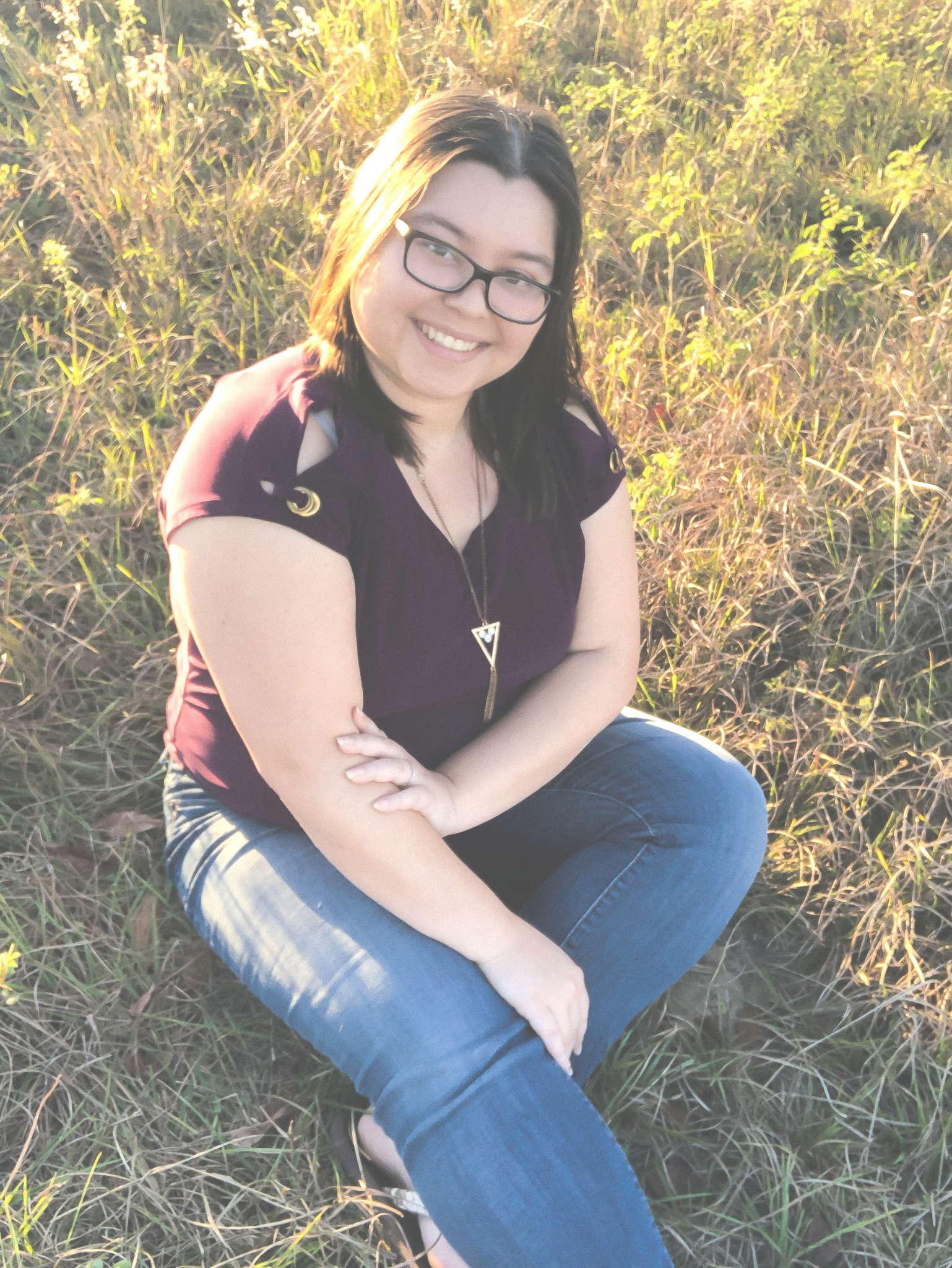 woman smiling and sitting in field