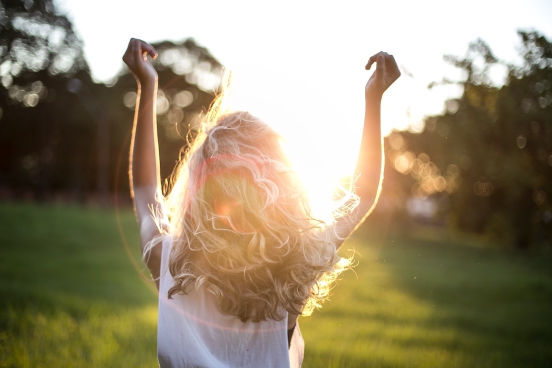 woman with arms up in the sunshine